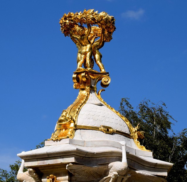 Musikerdenkmal, vergoldete Spitze mit drei Putten und einem Lorbeerkranz.
