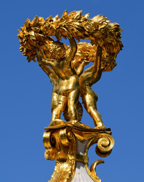 Musikerdenkmal, vergoldete Spitze mit drei Putten und einem Lorbeerkranz.